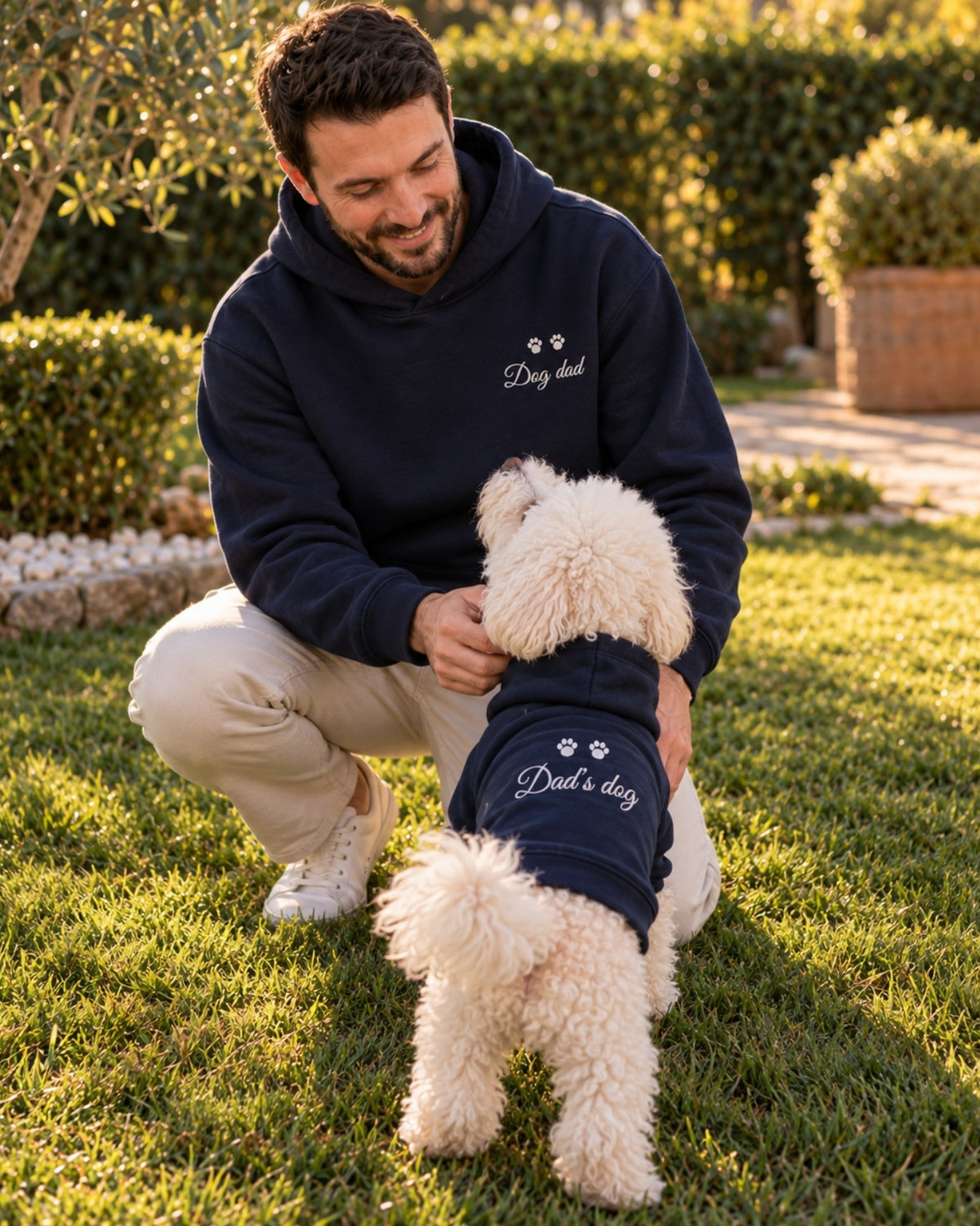 Uomo in giardino con Ben, felpe blu navy abbinate Dog dad e Dad's dog con ricamo grigio sulla schiena del cane