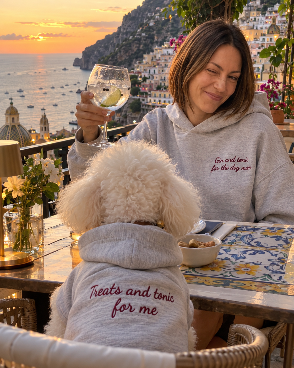 Set felpe abbinate Gin and tonic for the dog mom + Treats and tonic for me grigio melange: donna con gin tonic in terrazza sul mare e cane con felpa ricamata